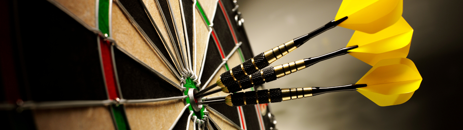 Dart board with three yellow darts in the middle